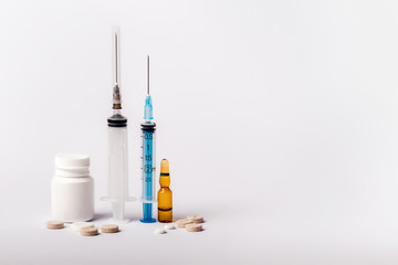 Medicaments on a white background. Syringe, pills, injection and other drugs to cure people and support health. Medicines and tablets against diseases and viruses.