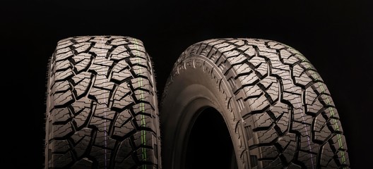two off-road wheels with a powerful tread, mud pattern with slats, cuts and checkers on a black...