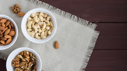 diet food concept, almonds, walnuts and cashew nuts on a wooden table