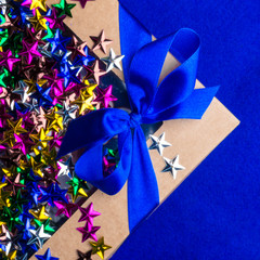 craft gift box with satin blue bow and colorful stars