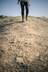 Woman hiking along rocky path with closeup shot of her boots