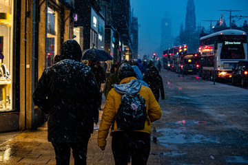 People walking in Princes Street during a snow in Edinburgh, UK.