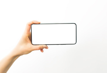 Hand holds a smartphone with a white screen. Blank mobile phone mockup