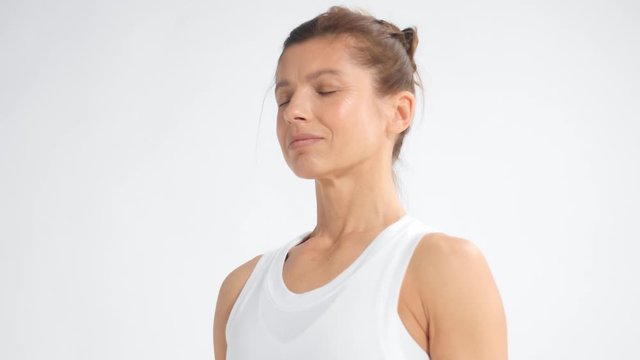 Senior woman in white space practice yoga closeup dolly portrait with eyes closed