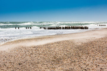 Ostsee bei Sturm, schaumgekrönte Wellen, Buhnen am Strand, Sand wird verweht