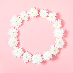 Beautiful flowers composition. Wreath made of white flowers on pastel pink background. Flat lay, top view, copy space, square