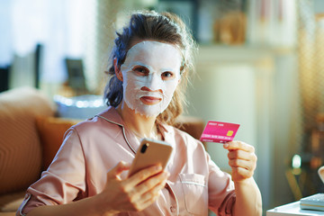 happy woman with facial mask with smartphone shop online