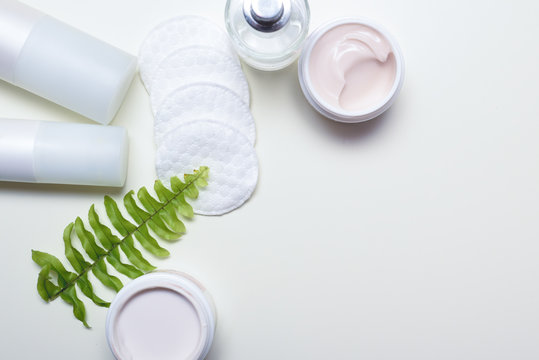 Facial cleansing products and containers with face creams and cotton wool pads
