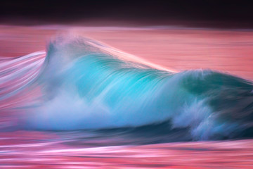 Photo of turquoise wave at sunset with in camera panning technique