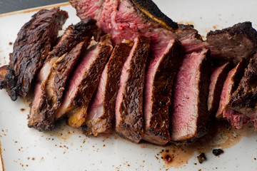 Steak. Grade A, grass fed angus beef. Traditional classic New York steakhouse menu favorite. T-bone steak, bone in, cooked to medium to rare and sliced. 
