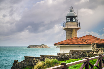 Suances lighthouse with Isla de los Conejos in the background, o