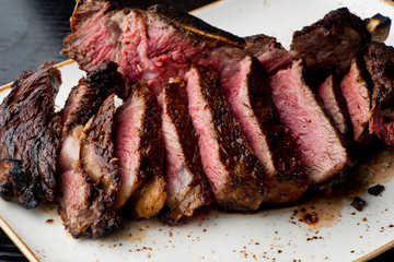 Steak. Grade A, grass fed angus beef. Traditional classic New York steakhouse menu favorite. T-bone steak, bone in, cooked to medium to rare and sliced. 