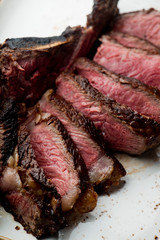 Steak. Grade A, grass fed angus beef. Traditional classic New York steakhouse menu favorite. T-bone steak, bone in, cooked to medium to rare and sliced. 