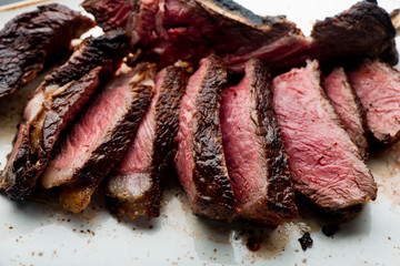 Steak. Grade A, grass fed angus beef. Traditional classic New York steakhouse menu favorite. T-bone steak, bone in, cooked to medium to rare and sliced. 