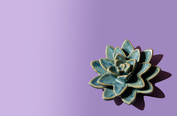 Blue lotus flower on violet background. Ceramic flower.