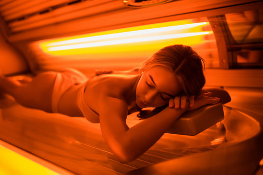 Beautiful young woman tanning skin treatment in modern solarium