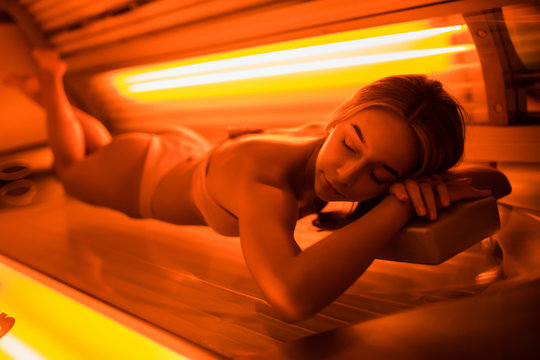 Young Woman Laying On Solarium Bed And Get Brown Skin Tone Ready For Summer