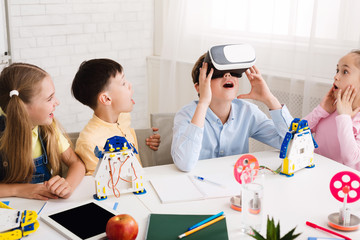 School boy using VR glasses at stem lesson