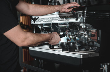 Fototapeta na wymiar Close up of barista hands preparing cappuccino for customer in coffee shop.