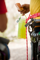 Two climbers, with mountaineering accessories, eat and drink water, hydration, detail shot