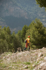 Fototapeta na wymiar mountaineer runs through the field with climbing equipment between mountains