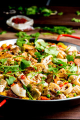 Paella. Traditional classic Spanish seafood dish with fresh seafood, shrimp, mussels, clams, squid cooked in fish broth with saffron and rice garnished with cilantro. 