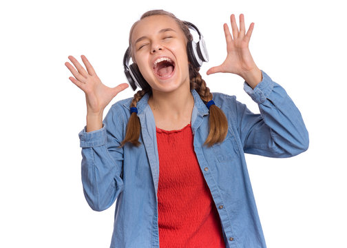 Portrait of happy teen girl with headphones, isolated on white background. Cheerful beautiful child listening to music and singing song. Emotional portrait of cute caucasian teenager enjoying music.