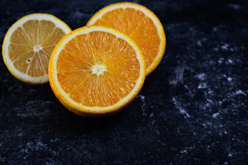 Fototapeta na wymiar Orange and lemon on a black background close-up.