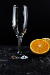 close up empty glass of champagne and oranges