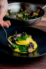 Ravioli. Traditional classic Italian restaurant menu favorite. Hand rolled pasta filled with meats and cheeses and topped with olive oil and garnished with Italian parsley. Dish plated by chef.