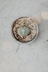 kommunion, konfirmation, firmung, taufe - Grüner Stein in mit Kreuz auf Kieselsteinen in Glas