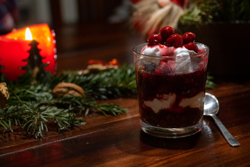 A vegan dessert with chocolate, cream and cherries on a table with Christmas decoration