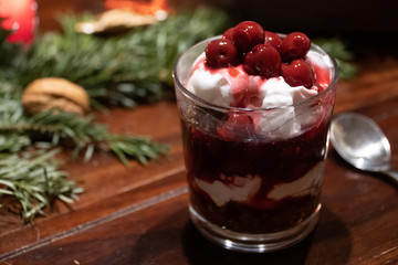 A vegan dessert with chocolate, cream and cherries on a table with Christmas decoration