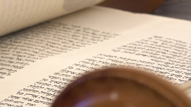 Aramaic and Hebrew letters from holy book Zohar or Kabbalah. Close up shot on sacred spiritual texts. Torah bible reading text with pointer.