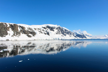 Fototapeta na wymiar Snow-capped mountains along the coasts of the Antarctic Peninsula, Antarctica