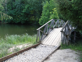 wooden bridge with railing over a small river
