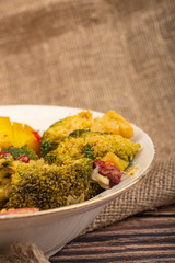 Vegetable salad in a white ceramic plate on a background of rough homespun fabric. Close up.