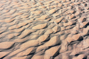 Footprints in the sand of the wild and sunny beaches of the Illetes in Formentera in the Balearic islands of Spain.