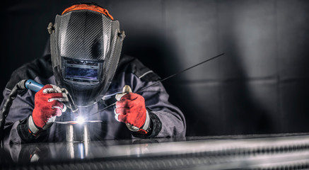 Welder industrial worker welding with argon machine - obrazy, fototapety, plakaty