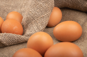 Chicken eggs against a rough homespun fabric. Homemade preparations, Rustic treats. Close up.
