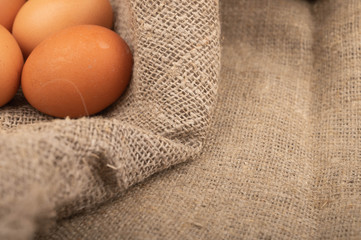 Chicken eggs on a background of rough homespun fabric. Country food. Close up.