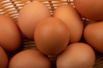 A few chicken eggs in a wicker basket. Country food. Close up.