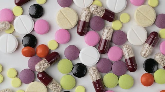 The medicine concept. Multicolored medicines background. Different remedy, pills, capsule, antibiotic and vitamin rotates.