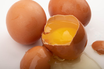 Broken chicken egg and eggs on a white background. Close up.