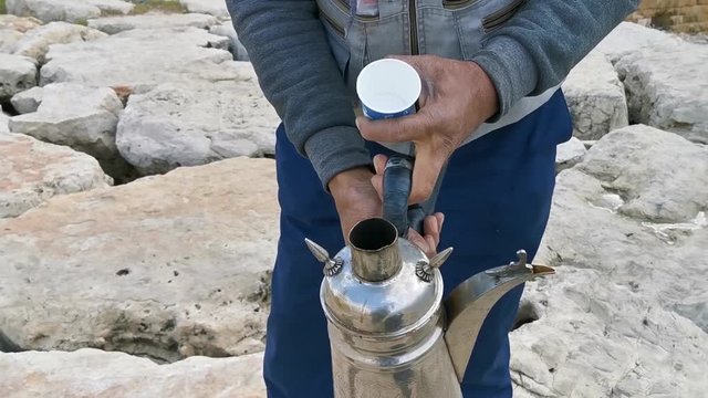 A man Selling Traditional Arabic Coffee to Tourists in Lebanon Saida Sea coast / Rock Beach