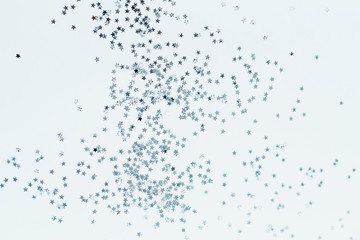 Silver stars shine on a bright pink background. Festive holiday bright background.