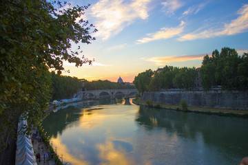 The River Tiber flowing peacefully through Rome at sunset during summer