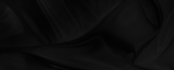 Black gray satin dark fabric texture luxurious shiny that is abstract silk cloth panorama background with patterns soft waves blur beautiful.