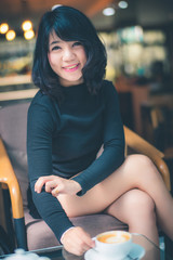 Beautiful attractive young Asian woman sitting at cafe or coffe shop in the morning
