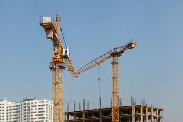 Construction site with cranes against the blue sky
